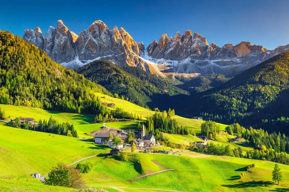 Un village pittoresque dans les Dolomites en Italie, idéal pour le camping. Des montagnes majestueuses, des prairies verdoyantes et des chalets traditionnels.