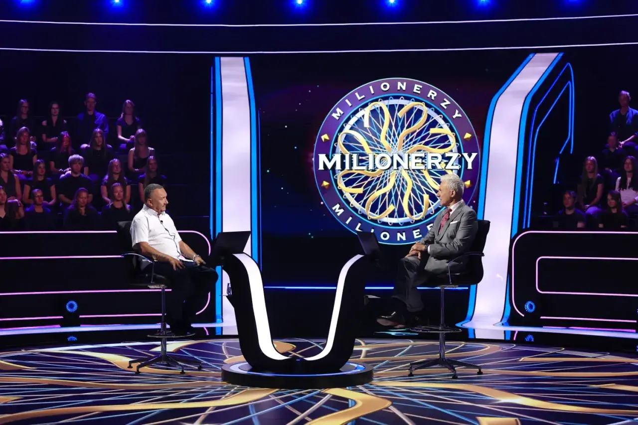 Oszczędny milioner siedzi na krześle w studiu telewizyjnym, gotowy do gry.