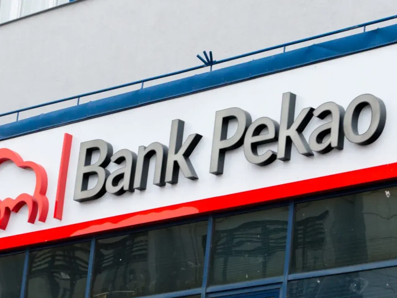 Logo Bank Pekao z czerwonym symbolem. Spokojna inwestycja z Pekao to pewność jutra.