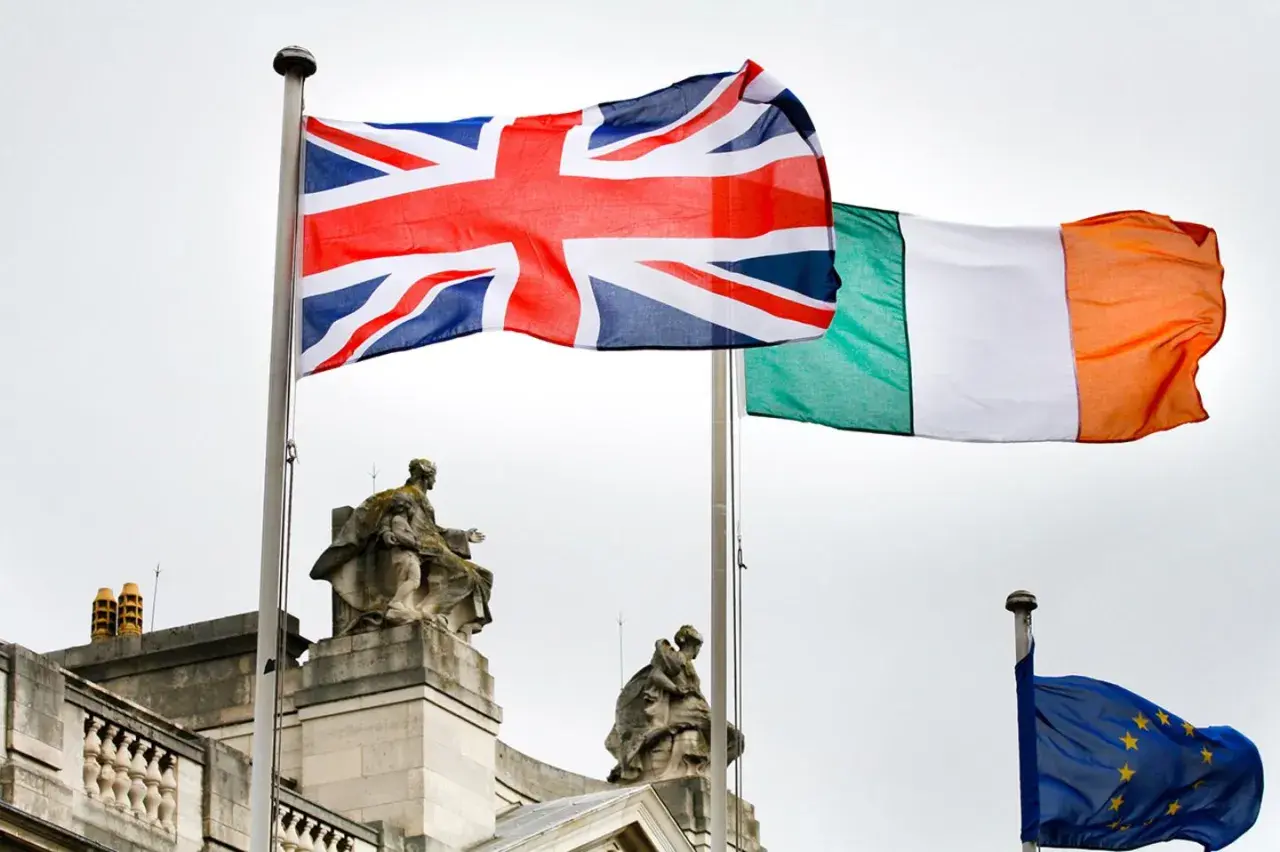 Union Jack und irische Flagge wehen nebeneinander. Die EU-Flagge ist im Hintergrund zu sehen.
