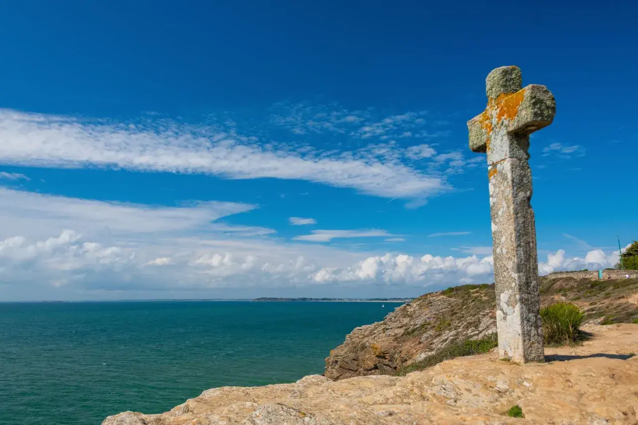 Croix de pierre patinée par le temps, dominant la mer d'un bleu profond. Une belle balade sur la presqu'île de Rhuys.