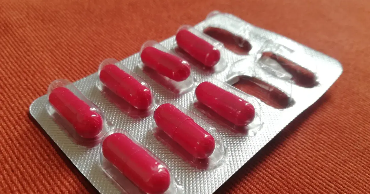 Czerwone kapsułki w blistrze. Może to suplement diety, np. cynk na co dzień, dla wzmocnienia odporności.
