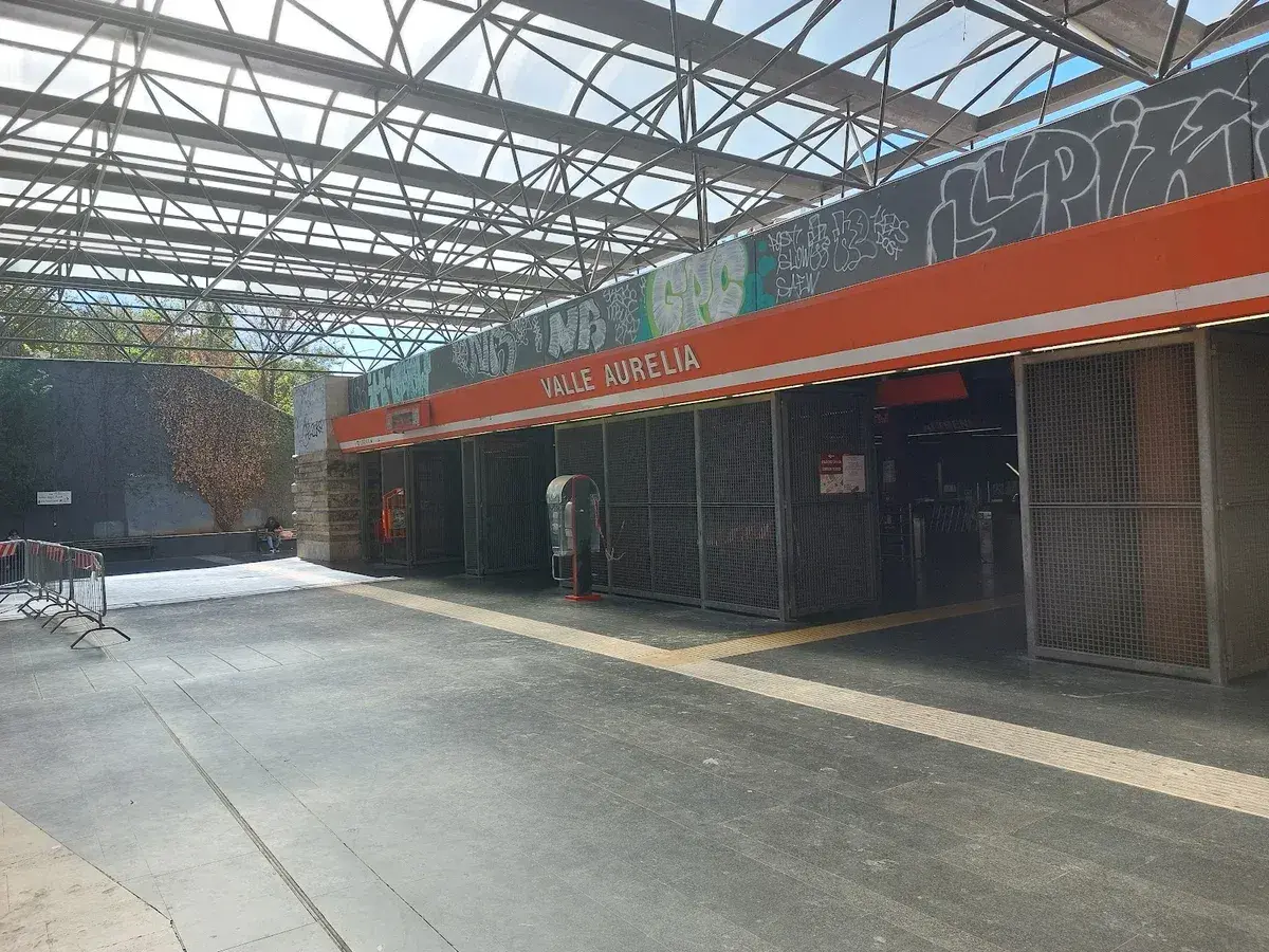 Ingresso della stazione **Valle Aurelia** a Roma, con tettoia metallica e graffiti.