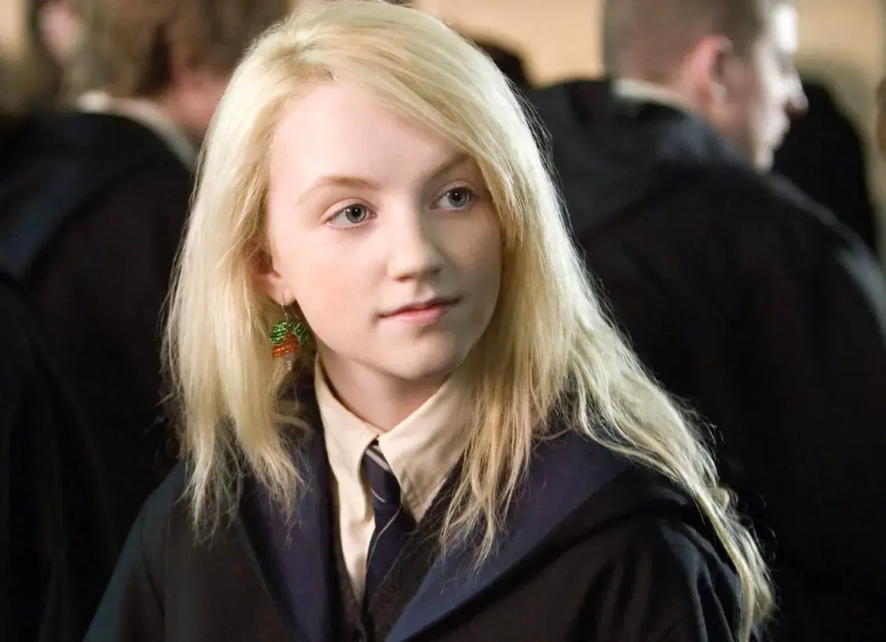 Evanna Lynch jako Luna Lovegood, z charakterystycznymi kolczykami z koralików, w szkolnym mundurku.