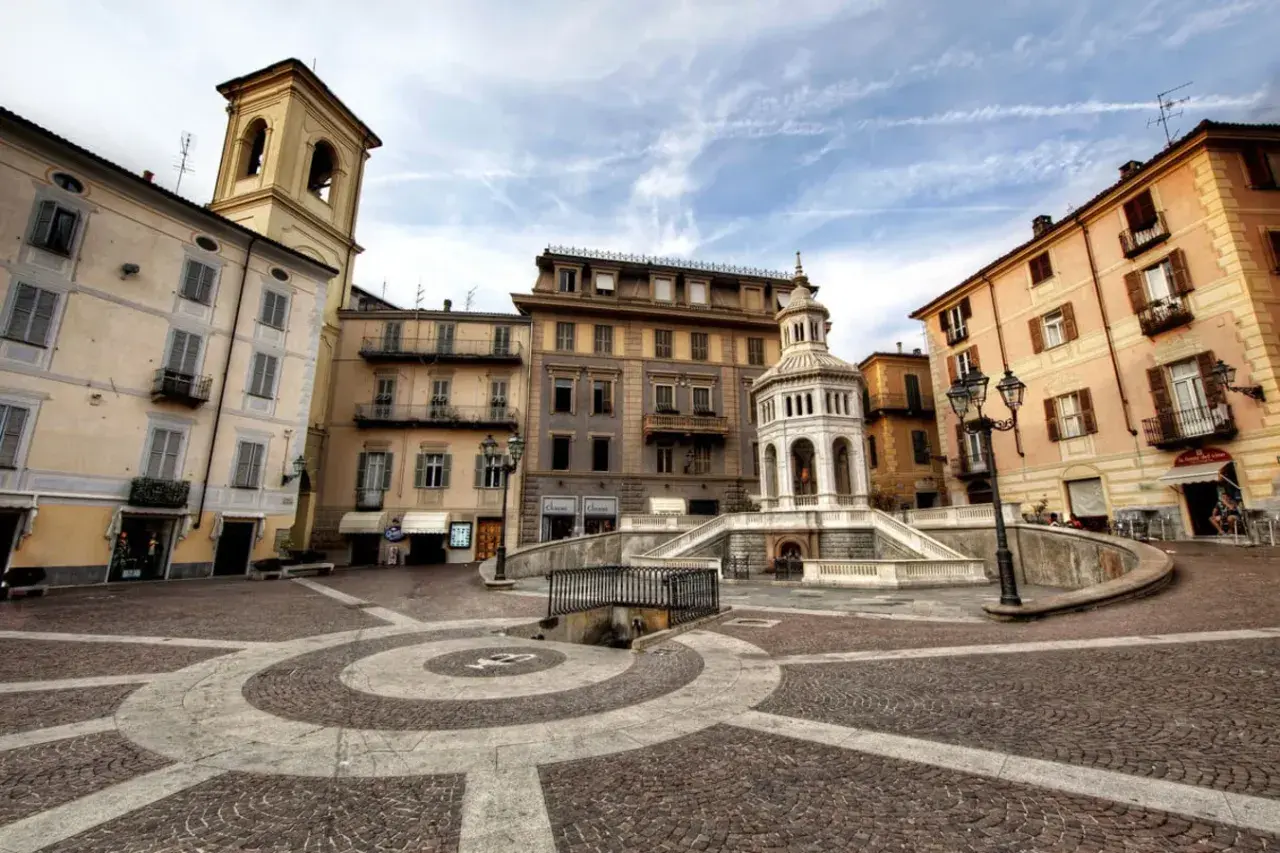Place de la ville avec une fontaine monumentale et des bâtiments colorés. Un endroit idéal pour se détendre et acqui terme.