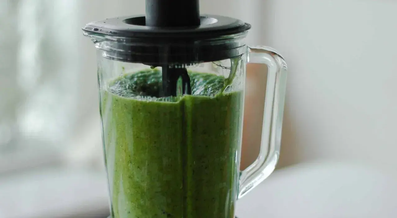 Ein grüner Smoothie wird im Mixer zubereitet. Dieses grüne Saft Rezept ist voller Vitamine.