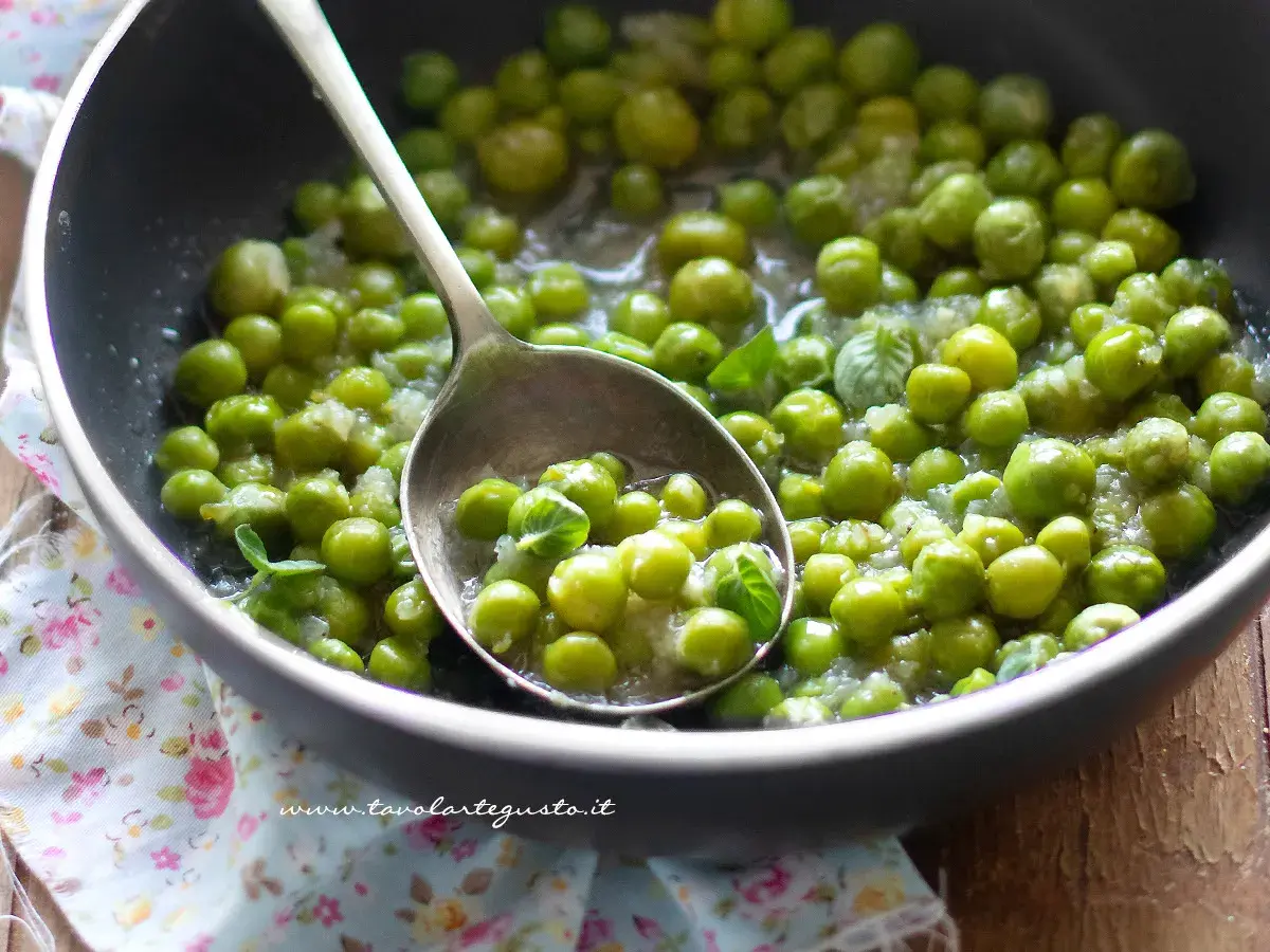 Piselli freschi in padella, cotti con cipolla e menta. Un contorno semplice e gustoso.