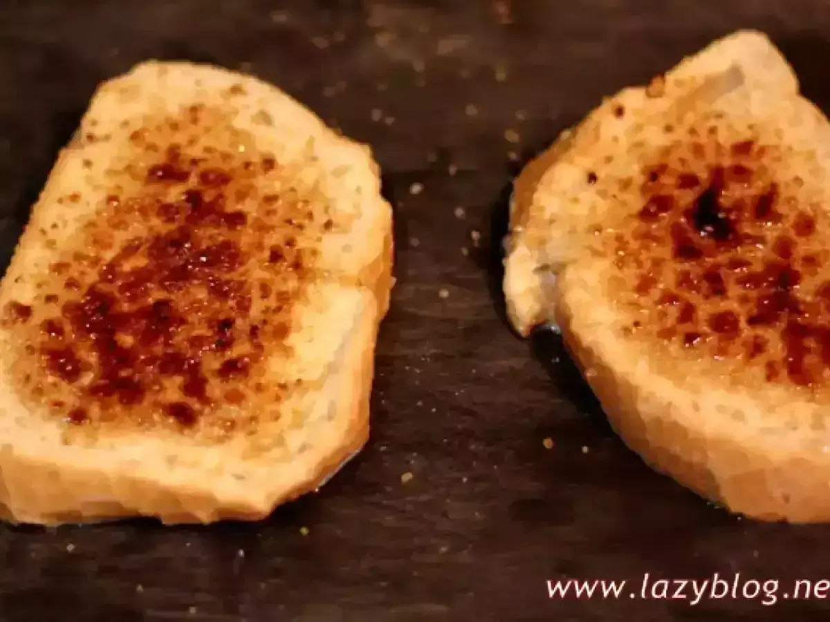 Dos rebanadas de pan tostado con azúcar caramelizada encima, listas para ser horneadas como torrijas.