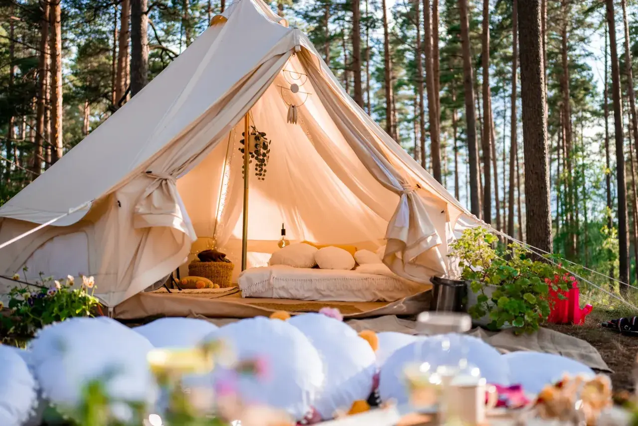 Przytulny namiot w lesie, idealny na glamping noclegi. Wygodne łóżko, dekoracje i atmosfera relaksu.