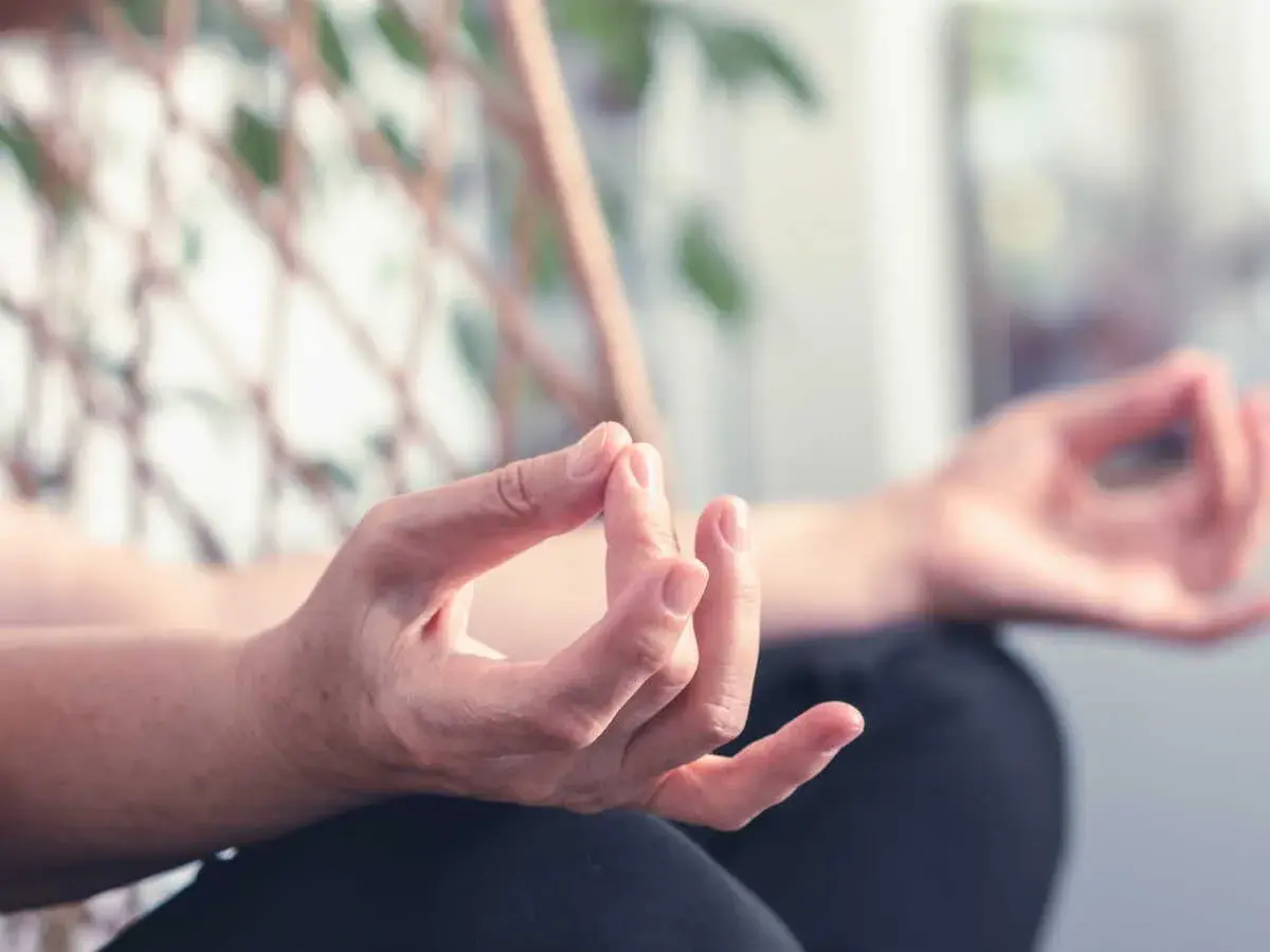 Mains en mudra, pratiquant des exercices de yoga des mains pour la relaxation et la concentration.