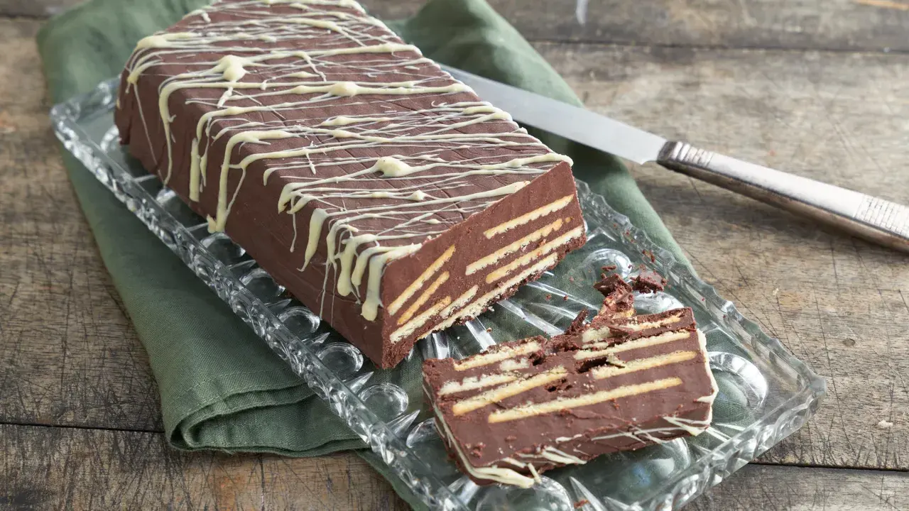 Schokoladenkuchen mit Keksen, ein leckeres rezept kalter hund ohne kokosfett, verziert mit weißer Schokolade.