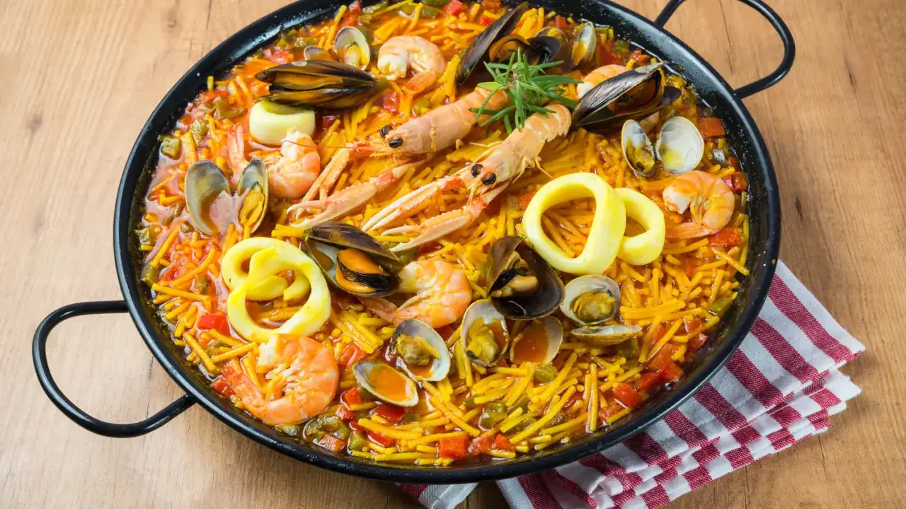 Fideuà catalane, un plat de pâtes aux fruits de mer, crevettes, moules, calamars et langoustines, prêt à être dégusté.