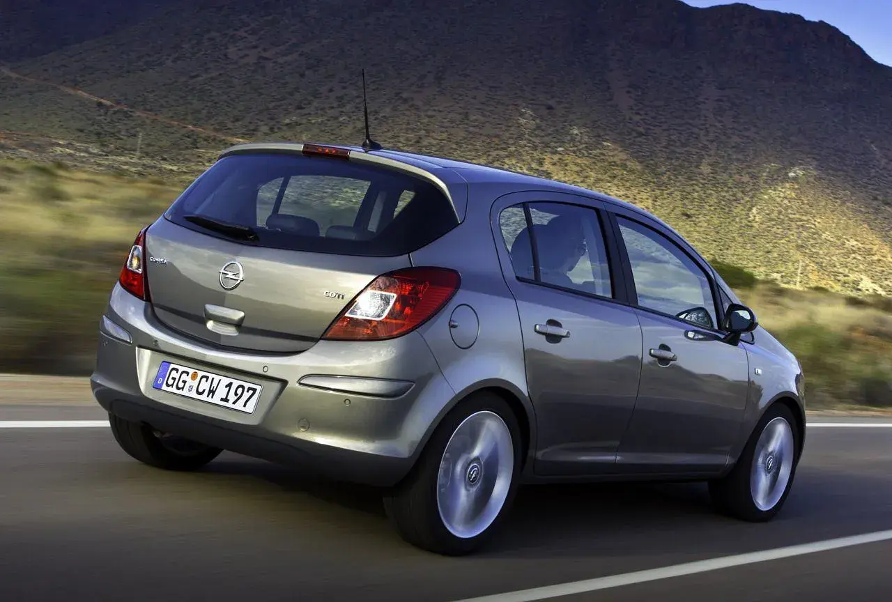 Szary Opel Corsa D 1.2 na drodze, z widocznym rozmiarem opon.