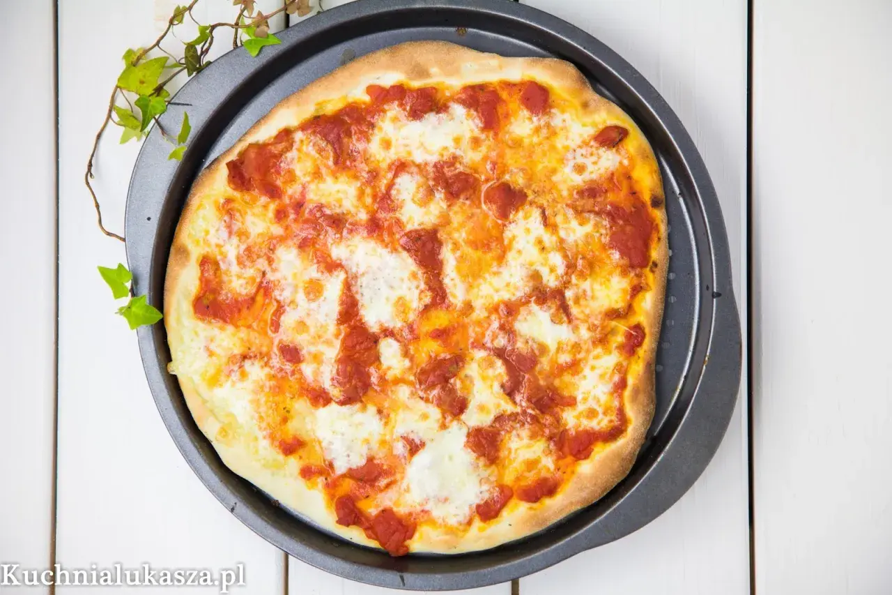 Pyszna pizza na miękkim cieście, z sosem pomidorowym i ciągnącym się serem, gotowa do podania.
