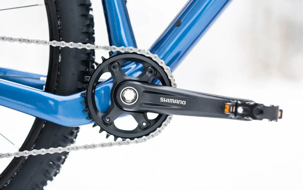 Widok na korbę Shimano i łańcuch roweru. Dowiedz się, jak odkręcić pedały w rowerze, by wymienić je na nowe.