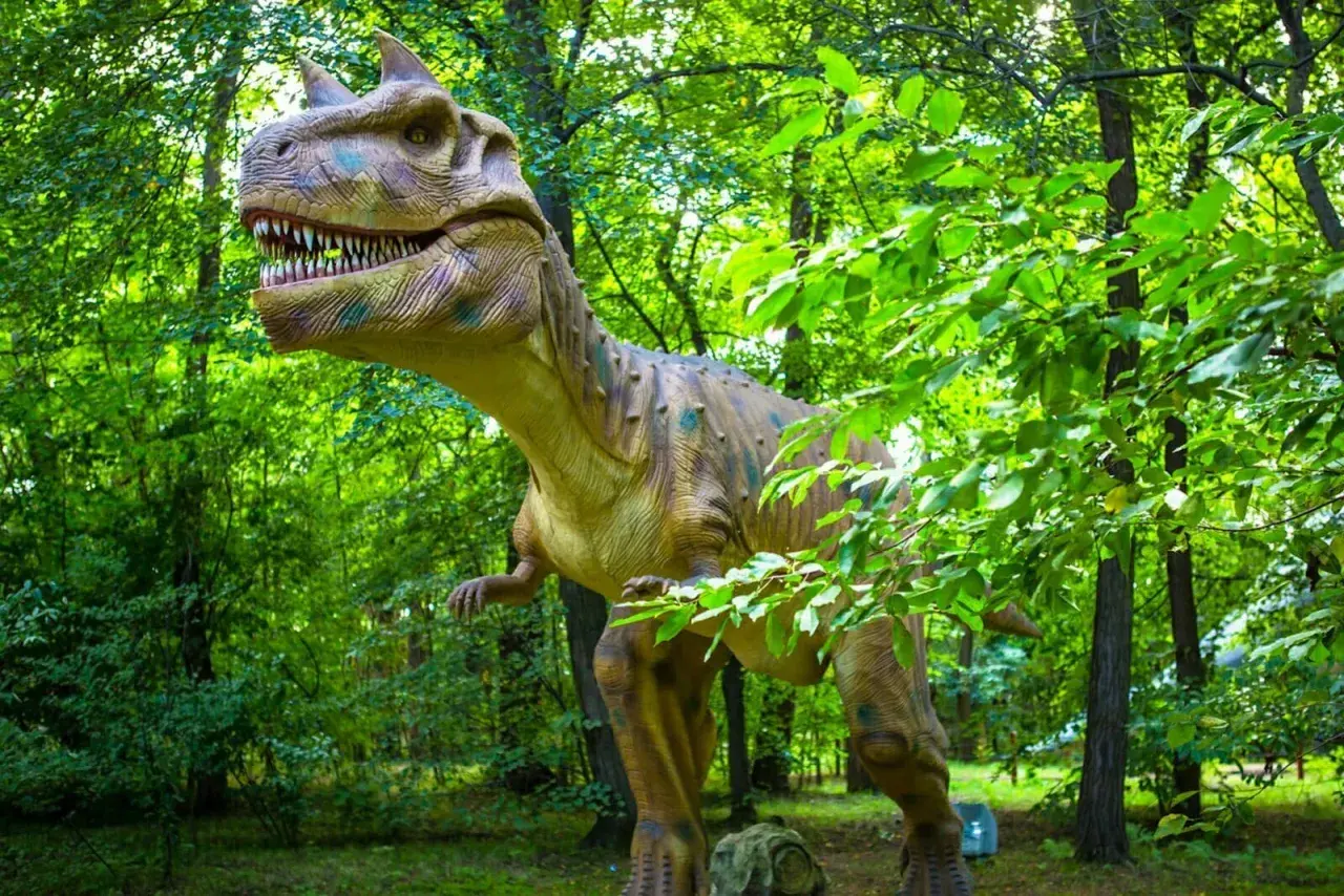 Witaj w parku ruchomych dinozaurów! Gigantyczny, realistyczny model tyranozaura czeka na Ciebie wśród bujnej zieleni.