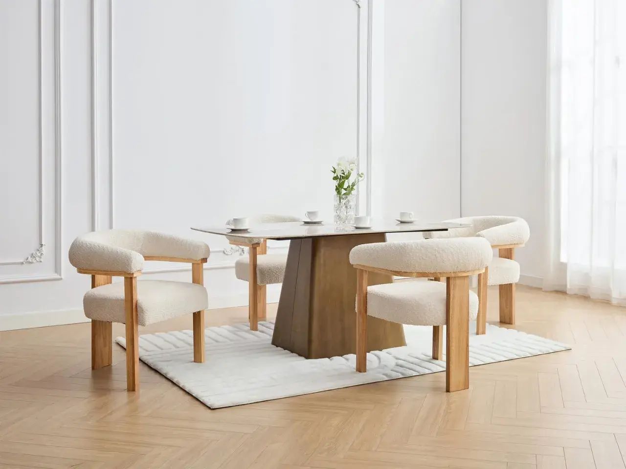 En elegant matplats med olika stolar runt ett modernt matbord. En vas med blommor står på bordet.