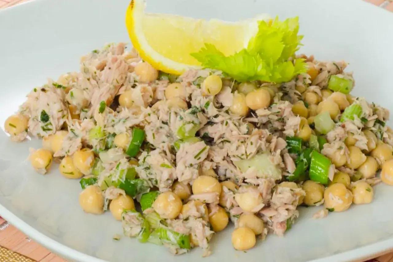 Insalata di ceci e tonno, fresca e saporita, guarnita con limone e sedano.