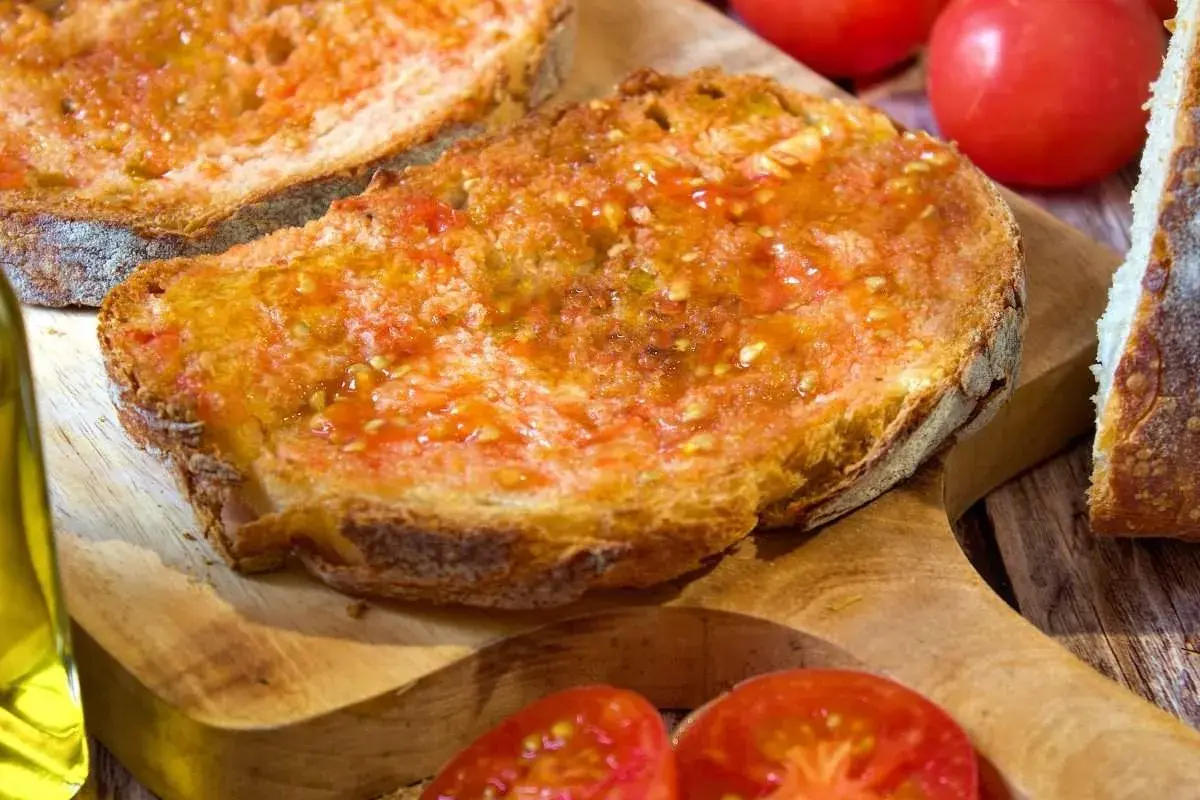 Rebanadas de pan tostado con tomate rallado y aceite de oliva, un delicioso pan de tomate listo para disfrutar.