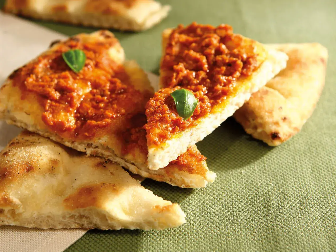 Tranches de pizza basilic, garnies d'une sauce rouge savoureuse et d'une feuille de basilic frais.