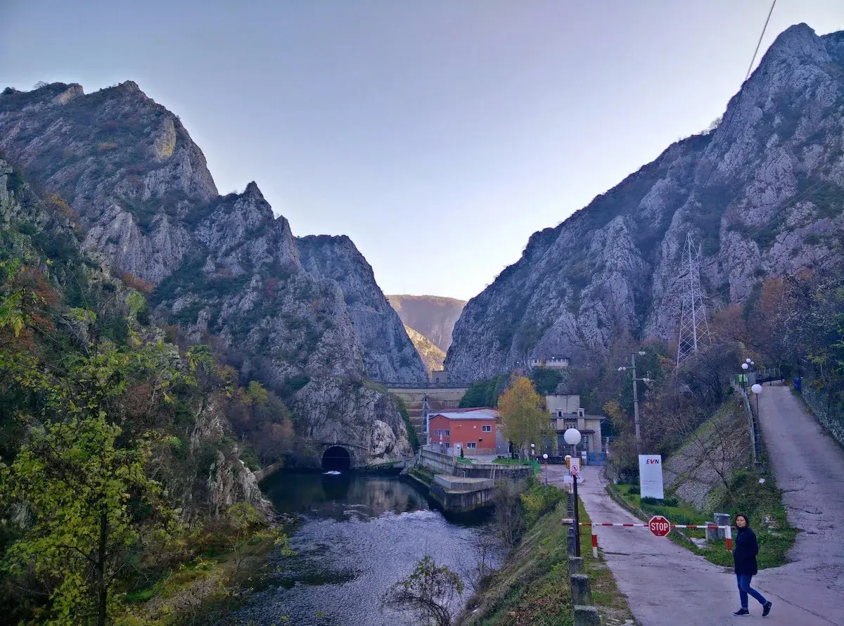 Wąwóz Matka, z potężnymi górami po bokach, rzeką i tunelem. Droga prowadzi do zapory.