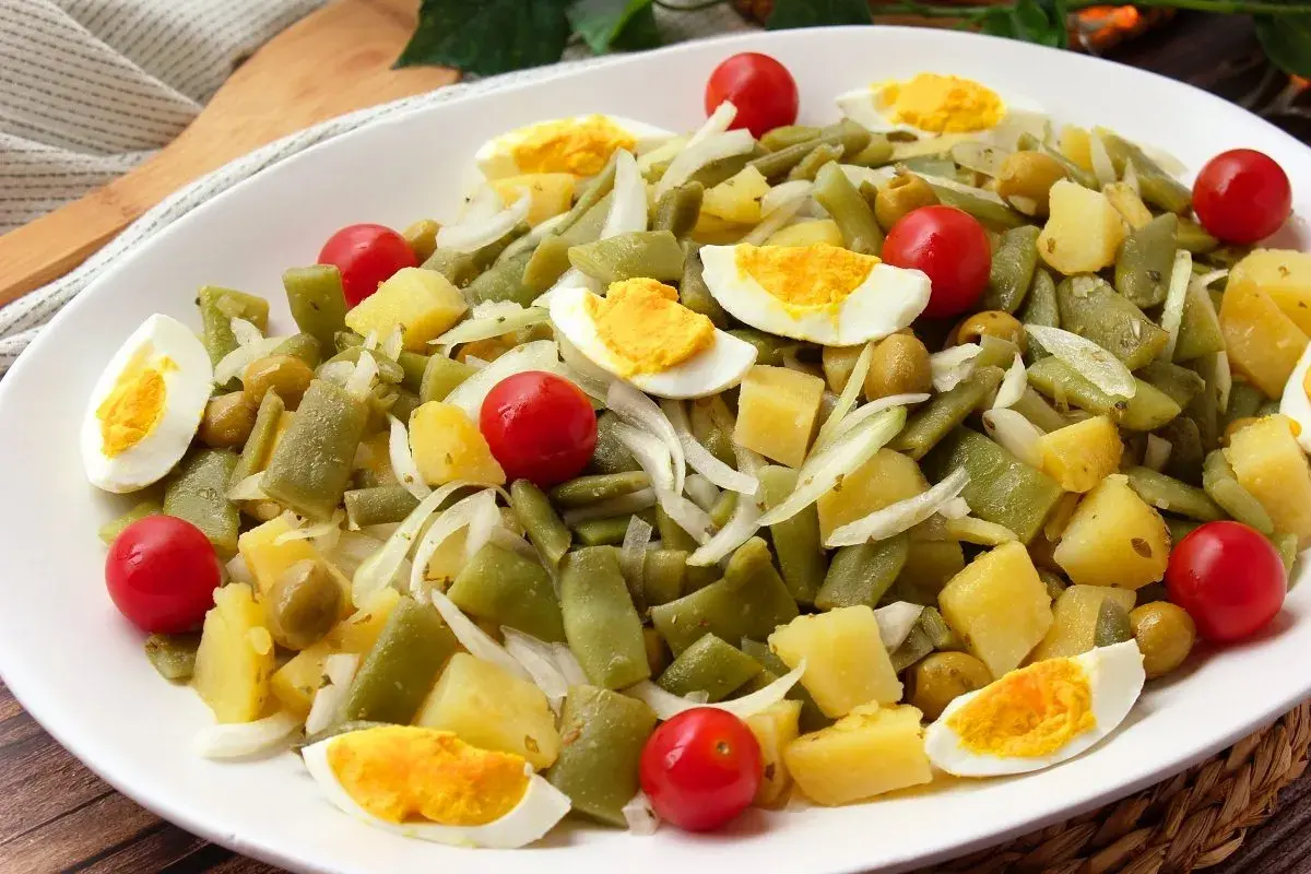 Deliciosa ensalada de judías verdes con patatas, huevo duro, tomates cherry y aceitunas. Un plato fresco y nutritivo.