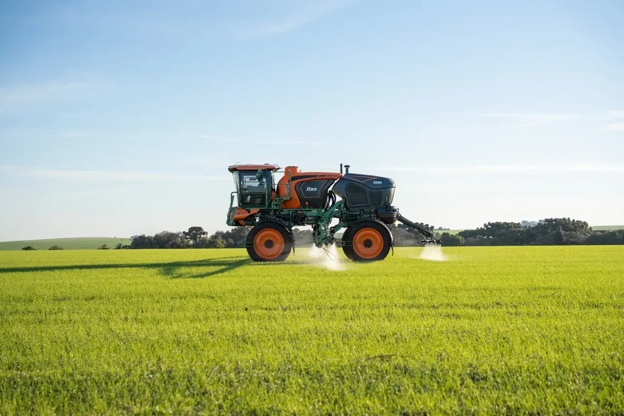 Pulvérisateur agricole Stara 3000 en action, assurant le nettoyage et la protection des cultures dans un champ verdoyant sous un ciel bleu.