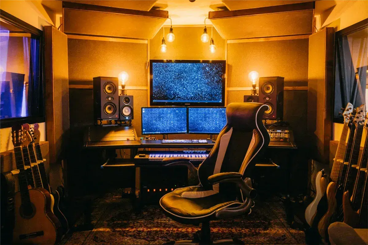 Ein Tonstudio mit Monitoren, Lautsprechern und Gitarren. Hier wird der **sound mixing** perfektioniert.