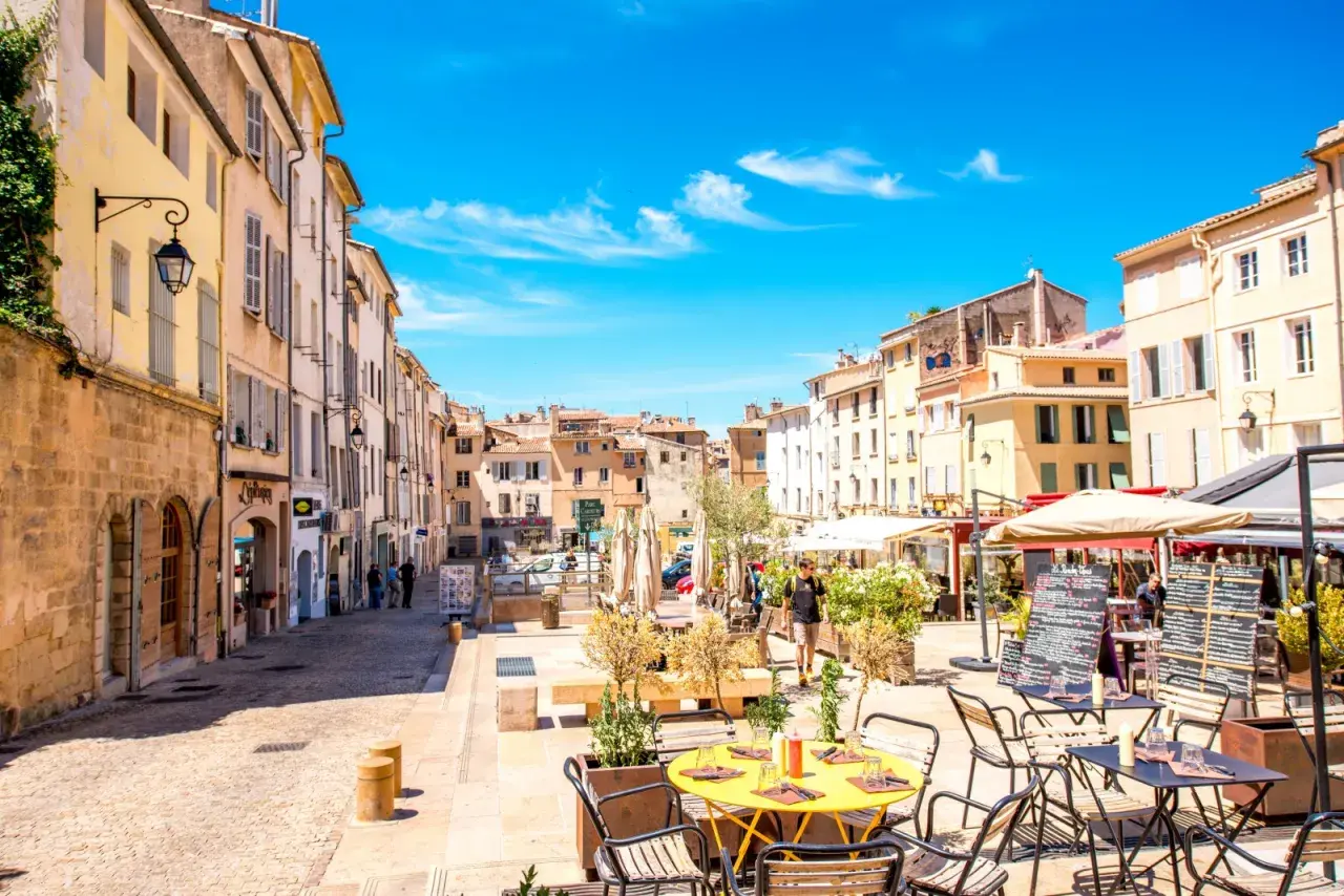 Sonniger Platz in Aix-en-Provence mit Cafés und Geschäften. Entdecken Sie hier die besten Aix-en-Provence Geheimtipps für Ihren Urlaub.