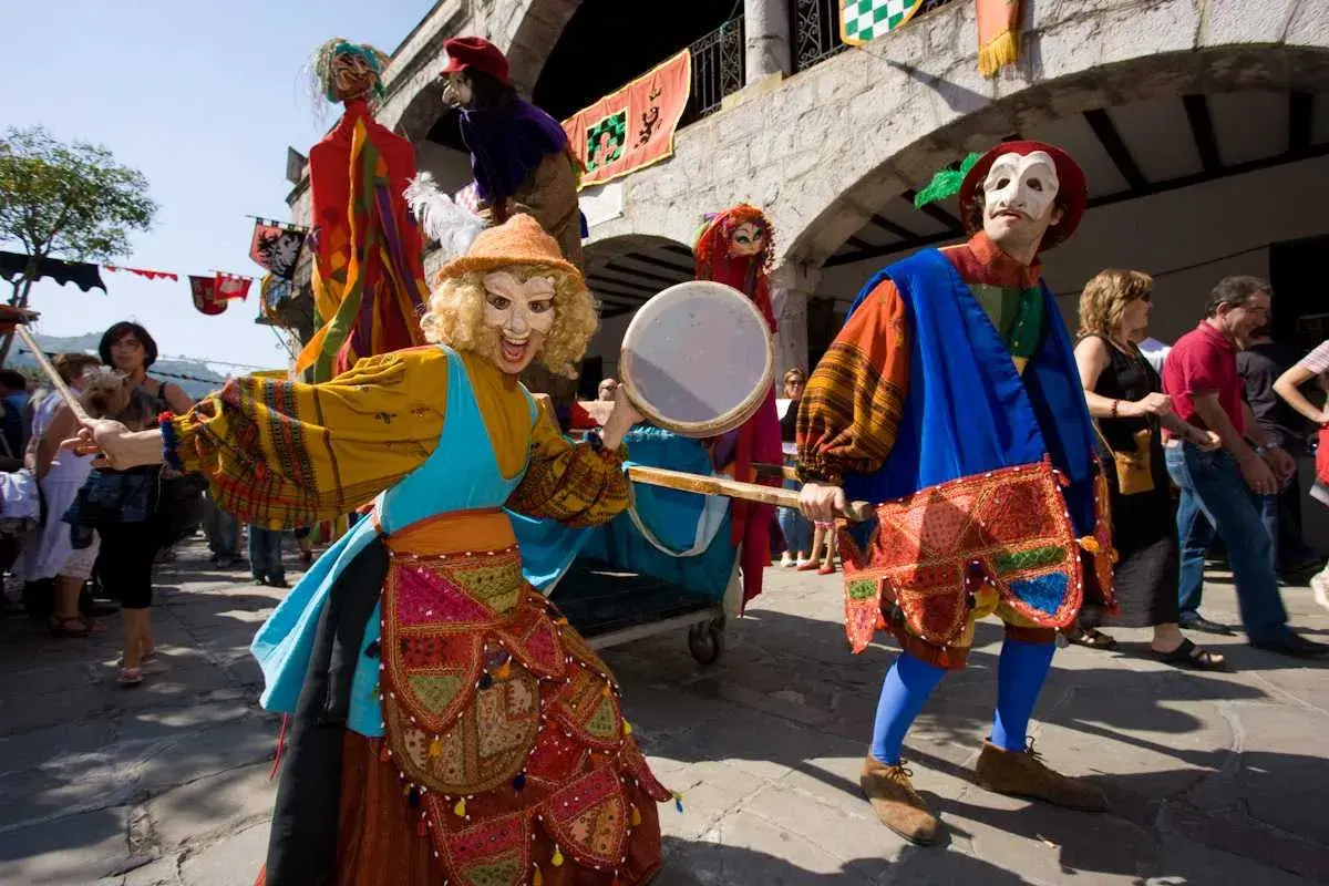 Recreación del desembarco de Carlos V en Laredo. Personajes con máscaras y trajes de época, uno toca un tambor.