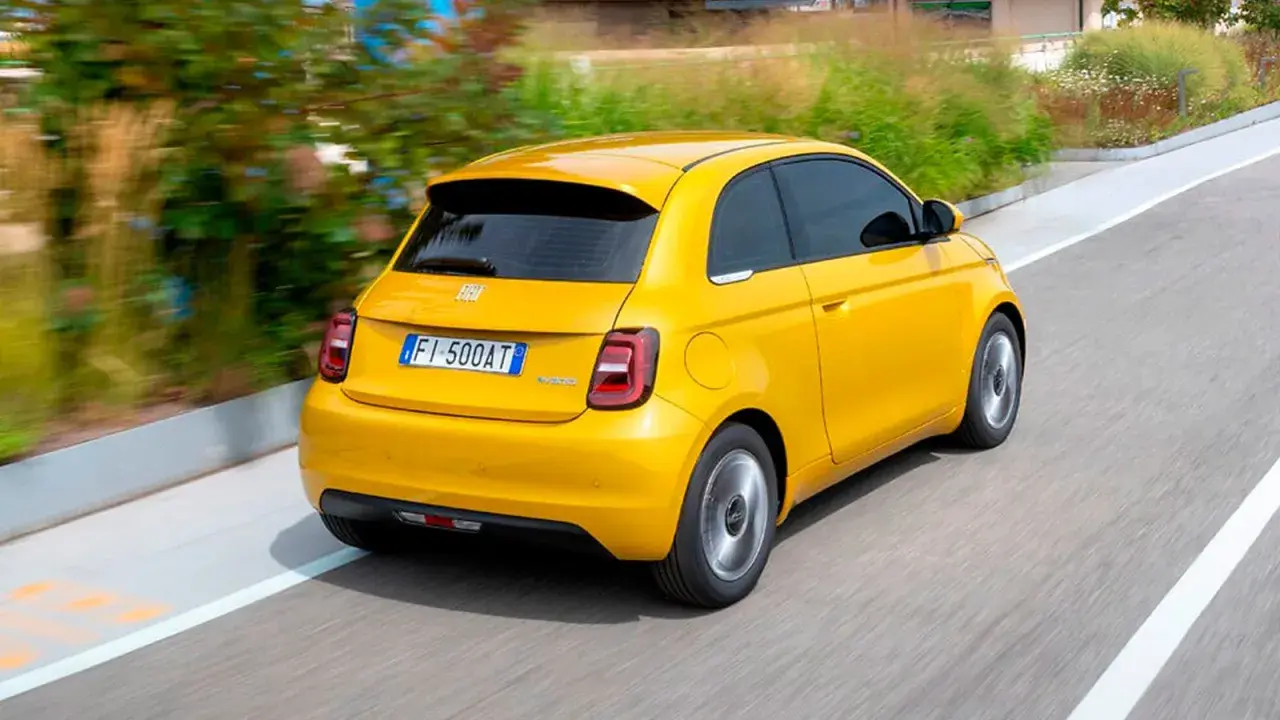 Un Fiat 500 Hybrid amarillo brillante en movimiento. ¡Una prueba de manejo emocionante!