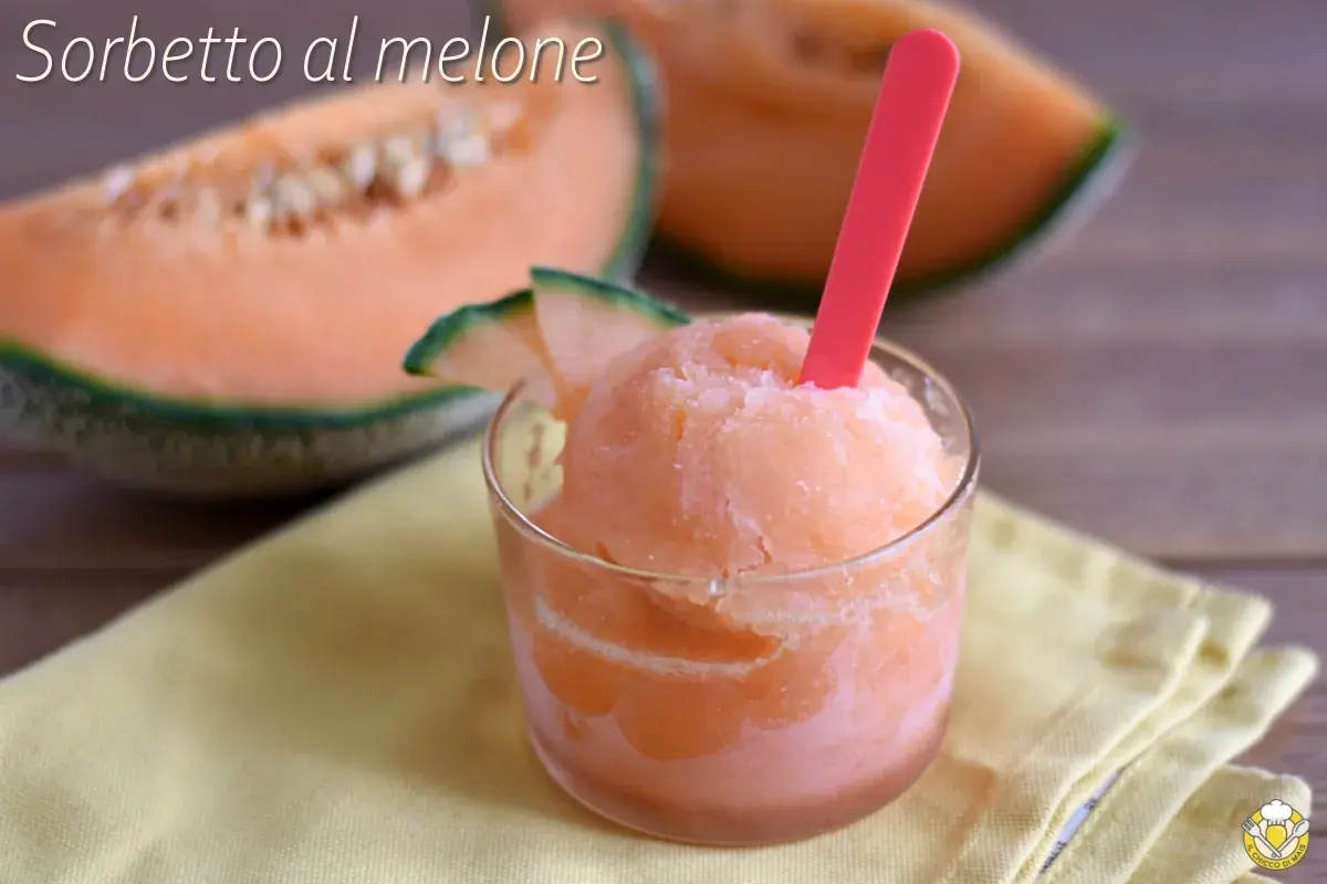 Sorbetto al melone rinfrescante in un bicchiere, con fette di melone fresco sullo sfondo.