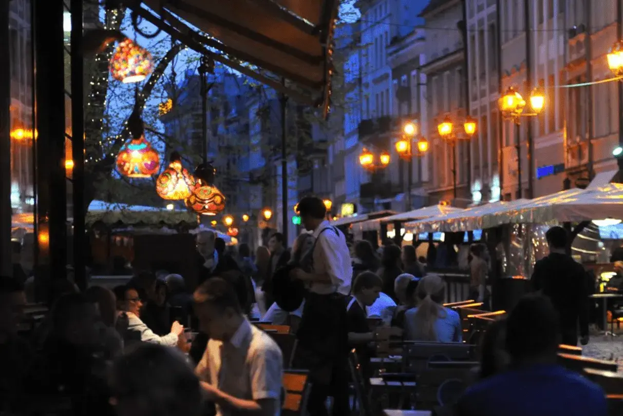 Wieczorny gwar kawiarnianego ogródka. Kolorowe lampiony i uliczne latarnie tworzą magiczną atmosferę. Może to właśnie tutaj odbywa się ostatni kawalerski wieczór?