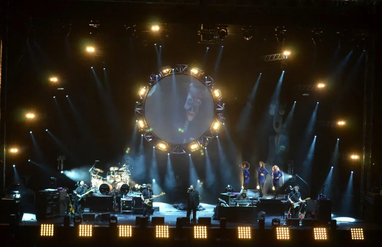 Koncert Australian Pink Floyd z okrągłym ekranem i wokalistami na scenie.
