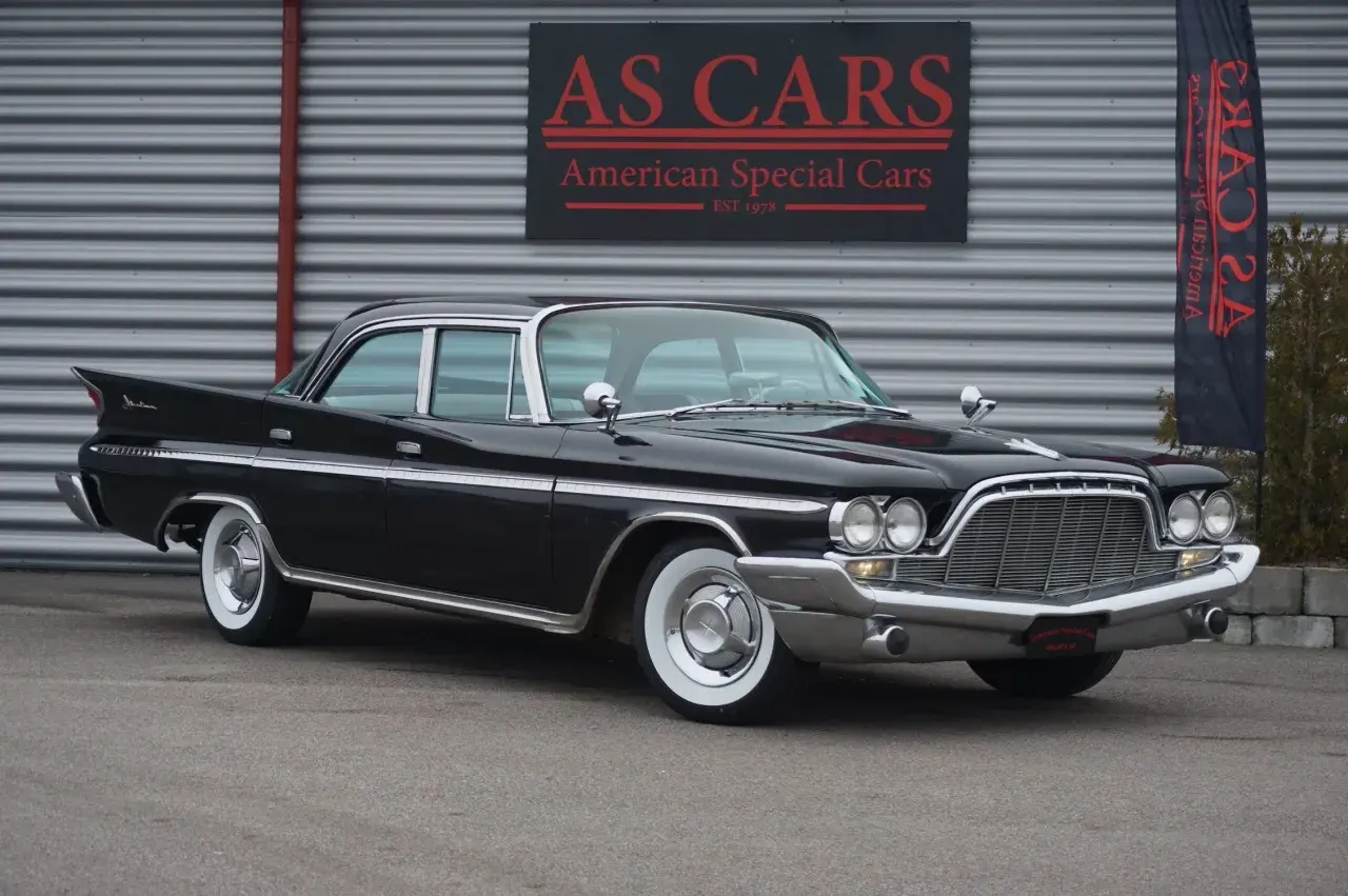 Svart de Soto bil med kromdetaljer och vita däcksidor framför AS CARS. En klassisk amerikansk dröm.