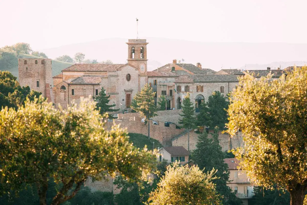 Borgo antico di San Ginesio, con la sua torre e la chiesa, immerso nel verde. Un paesaggio maturo, come un frutto pronto da gustare.