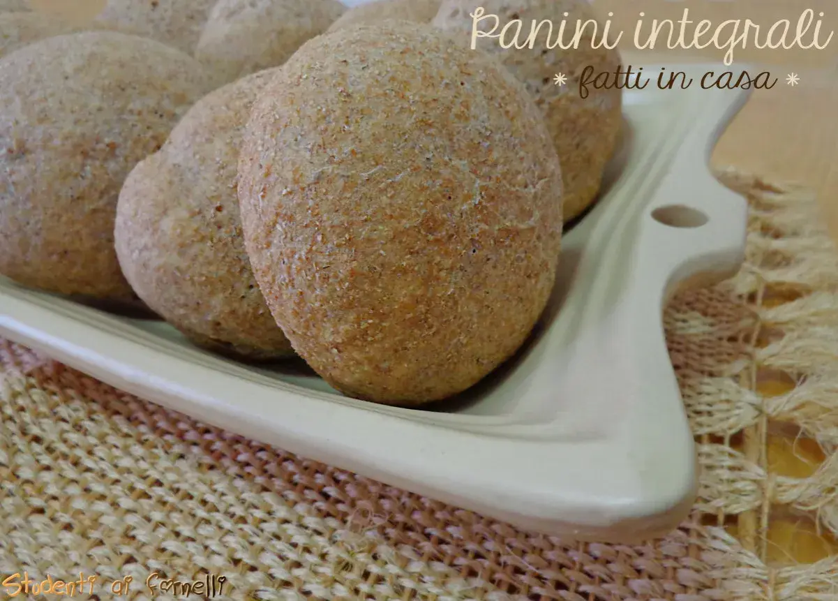 Panini integrali fatti in casa, morbidi e fragranti, serviti su un piatto bianco.