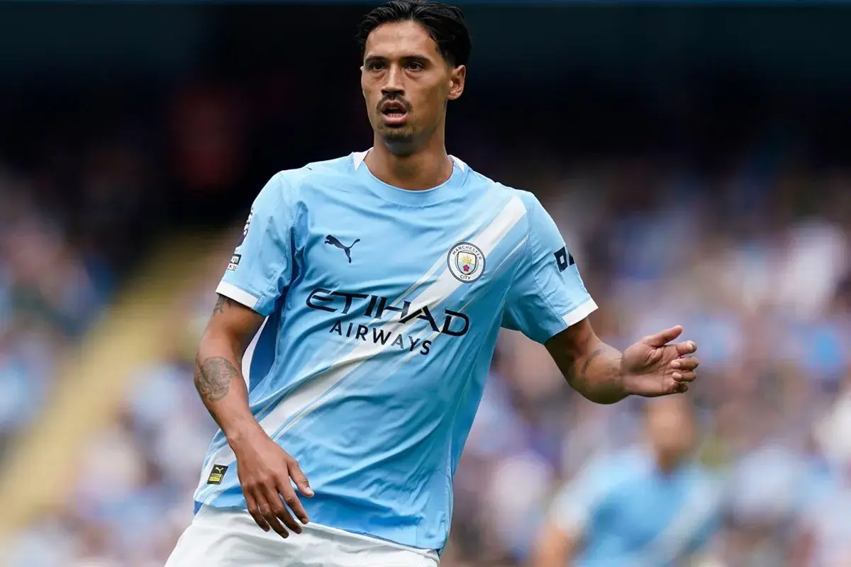 Piłkarz Manchester City w jasnoniebieskiej koszulce z logo klubu i napisem Etihad Airways.