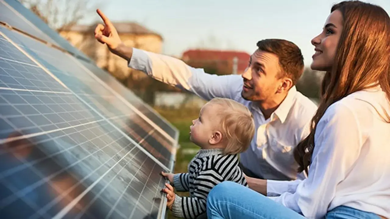 Rodzina podziwia panele fotowoltaiczne w Polsce. Ojciec pokazuje dziecku, jak działa czysta energia.