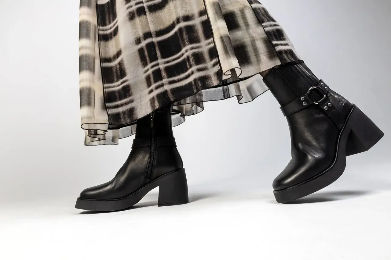 Jambes portant une robe à motif abstrait et une tenue avec bottines noires à talon épais et plateforme.