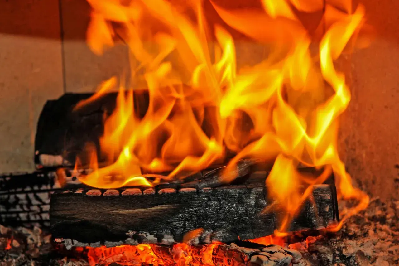 Glühende Kohlen und Flammen zeigen den hohen **erle brennwert** eines Kaminfeuers.