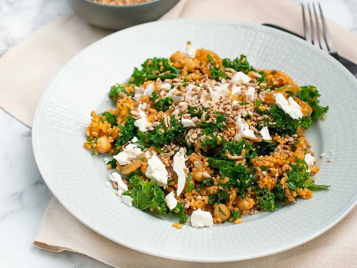 En läcker bulgursallad med grönkål, kikärtor och fetaost, toppad med solrosfrön.