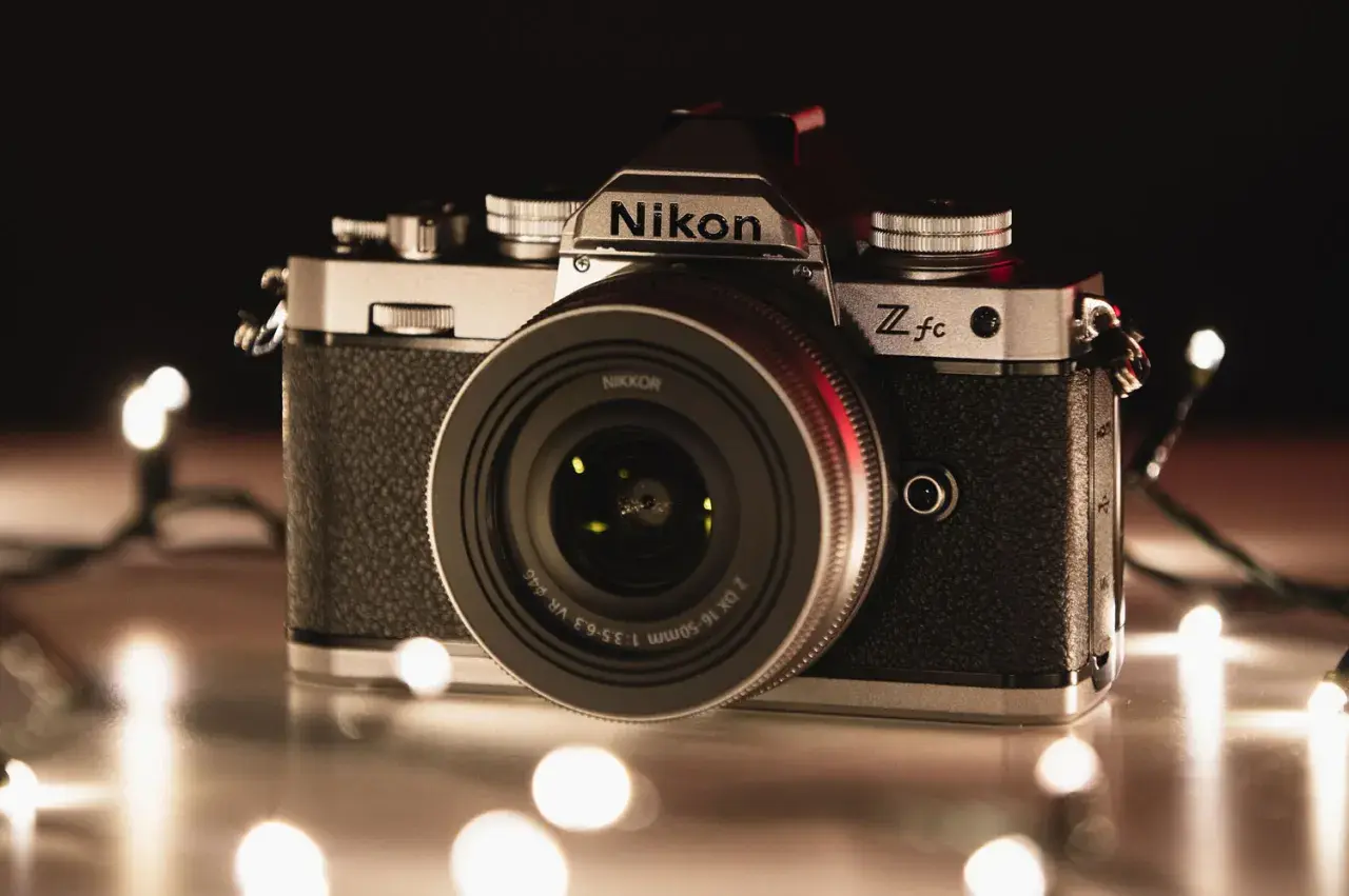 Nikon Z fc, jeden z rodzajów aparatów, otoczony świątecznymi lampkami.