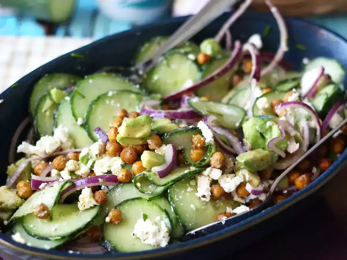Deliziosa insalata di cetrioli con ceci croccanti, avocado cremoso, cipolla rossa e formaggio feta sbriciolato.