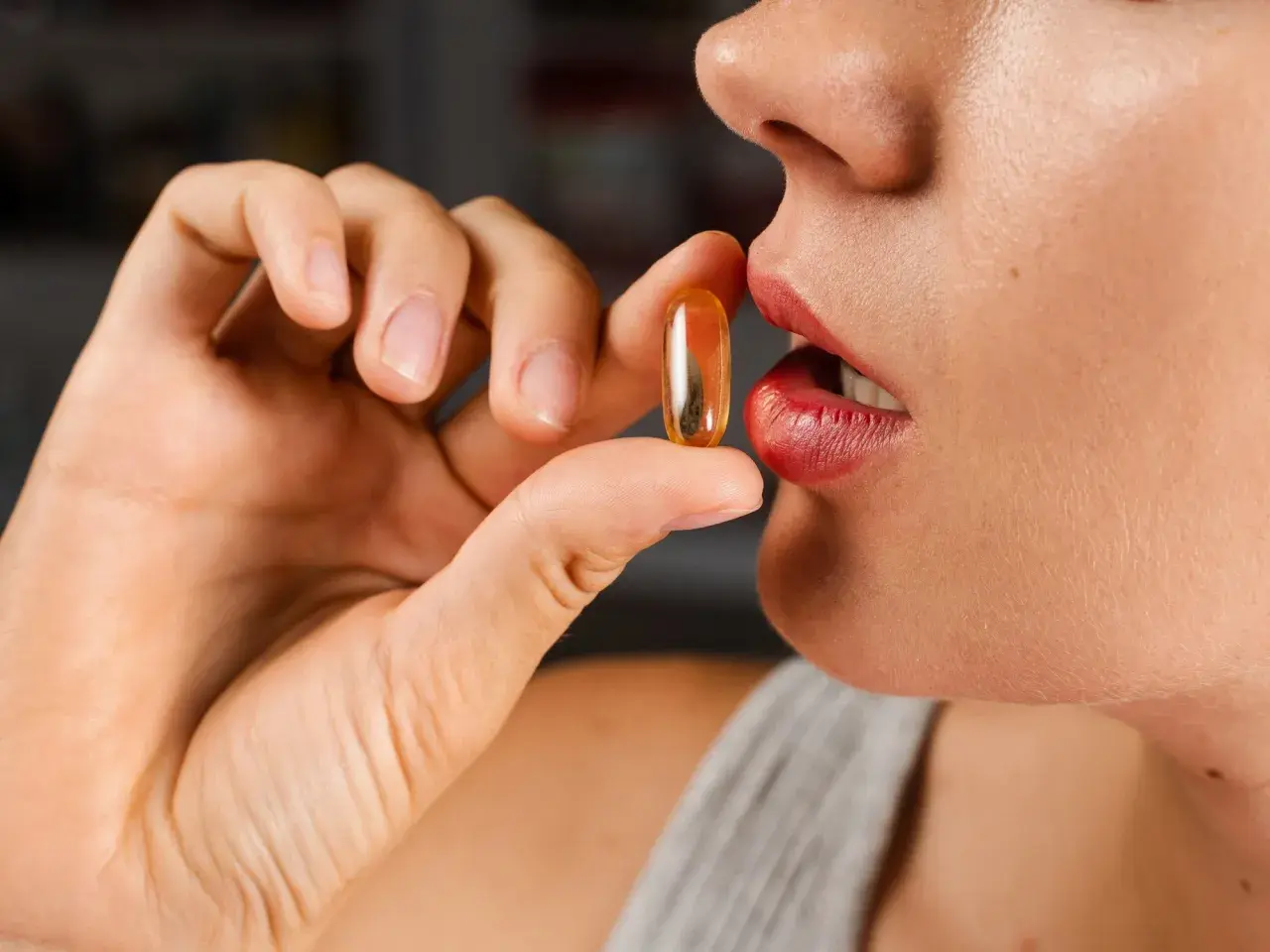 Mujer a punto de tomar una cápsula de colágeno. ¿Cuál es la mejor hora para tomar colágeno?