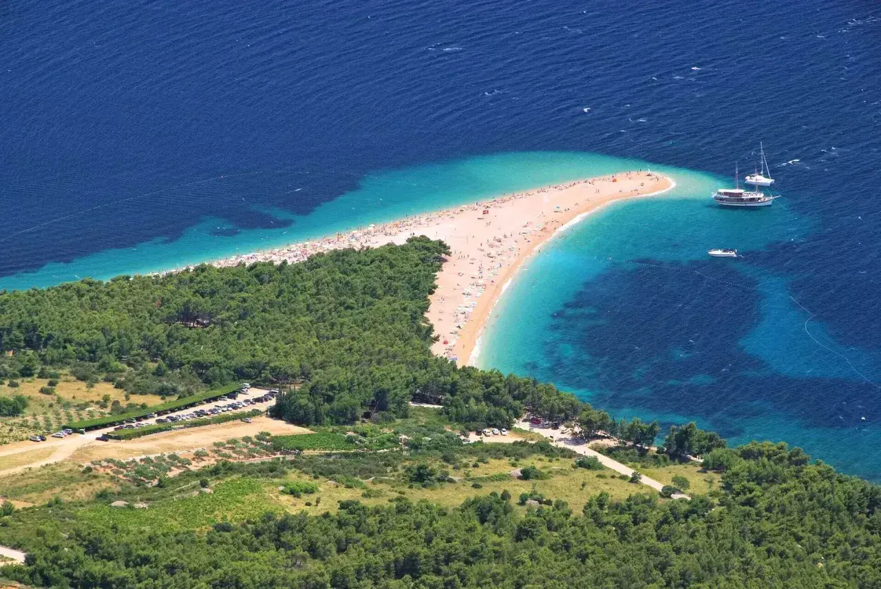 Plaża Zlatni Rat w Chorwacji, idealna na bezpośrednie loty do Chorwacji. Woda kusi turkusowym kolorem.