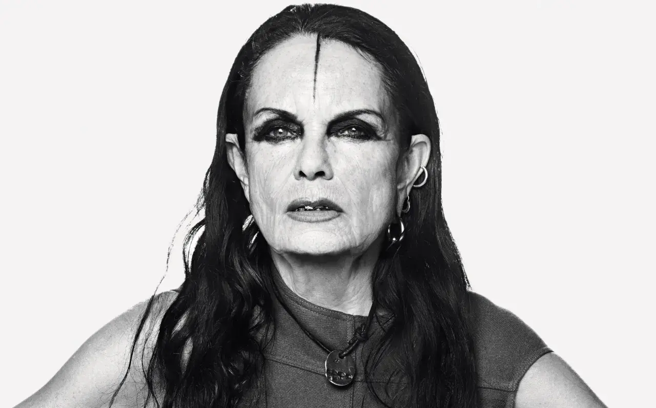 Black and white portrait of Michèle Lamy with dramatic eye makeup and a line drawn on her forehead.