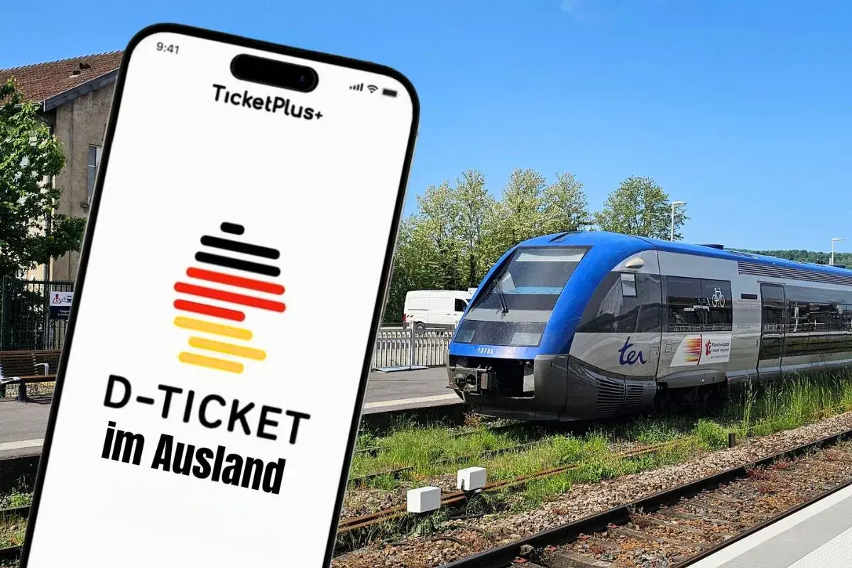 Smartphone-App zeigt "D-TICKET im Ausland" mit Deutschlandflagge. Im Hintergrund ein blauer Zug am Bahnsteig.