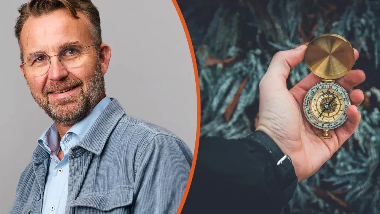 Man med glasögon och kompass i handen, symbol för att navigera i en VUCA-värld.