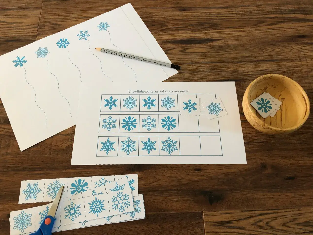 Actividades invierno Montessori: hojas con copos de nieve para recortar y completar patrones. Tijeras y lápiz listos.